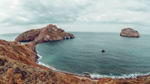 Scenic view of rocks in sea against sky