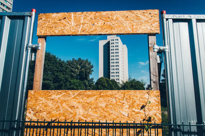 Building against sky seen through broken fence