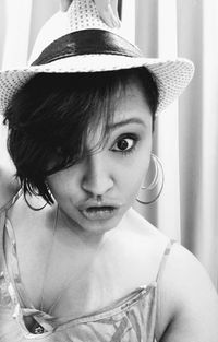 Close-up portrait of woman wearing hat at home