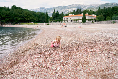 Full length of woman on shore by lake