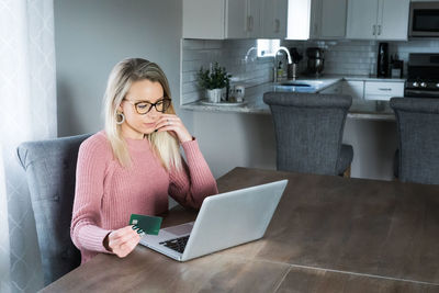 Midsection of woman using mobile phone at home