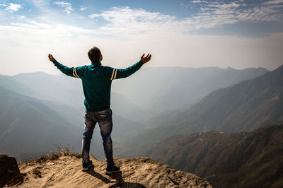 Full length of man standing on mountain against sky