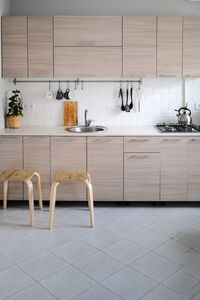 Bright kitchen set with stainless steel sink and facades with wood texture