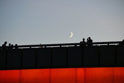 Silhouette people against clear sky at dusk