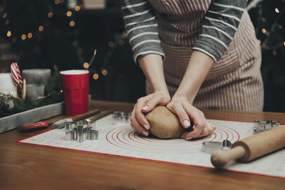 Midsection of woman holding table at home