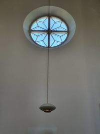 Low angle view of illuminated pendant light hanging from ceiling