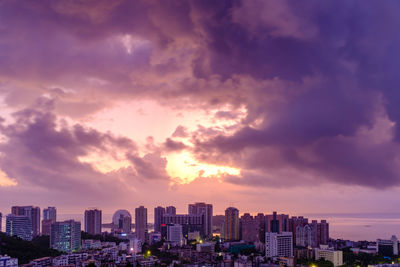 Buildings in city against sky at sunset