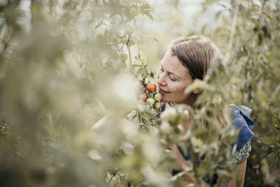 Woman holding flowering plant on field