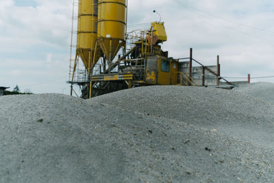 Construction site on beach against sky
