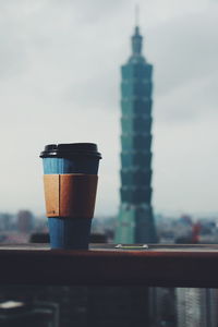 Coffee cup and building against sky