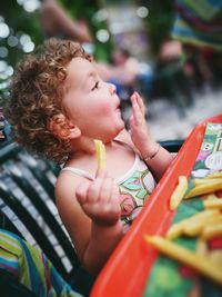 Close-up of boy eating fries at table