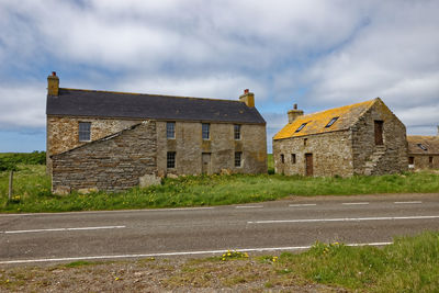 Road amidst buildings against sky