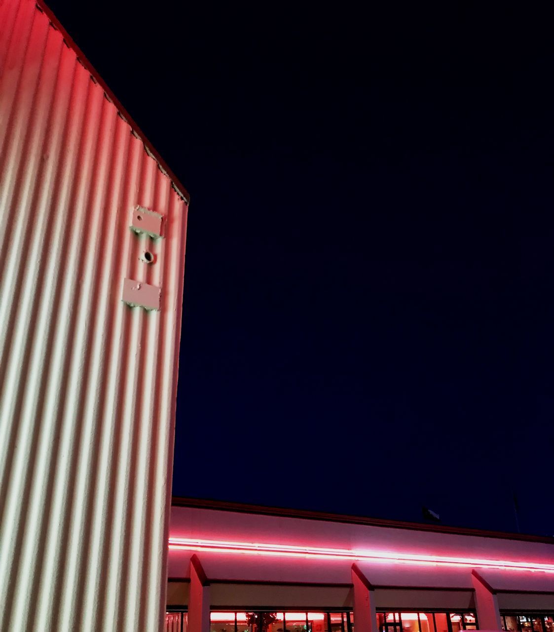 red, copy space, night, no people, architecture, low angle view, illuminated, sky, built structure, building exterior, nature, metal, outdoors, entrance, lighting equipment, pattern, clear sky, roof, communication