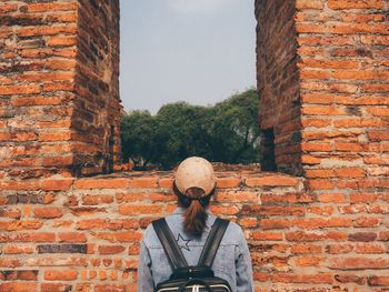 Man standing against brick wall