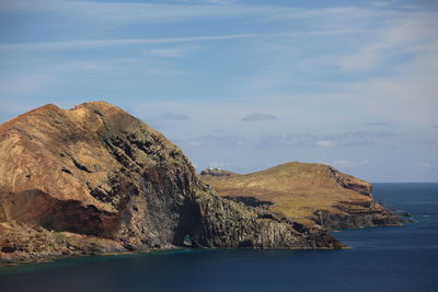 Rock formations by sea against sky