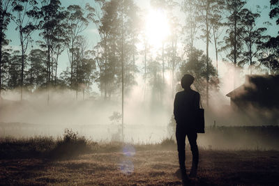 Rear view of man on field during foggy weather