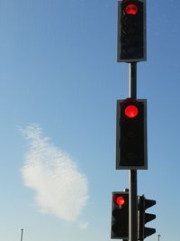 Low angle view of road signal against sky