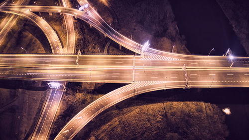 Light trails on bridge over street at night