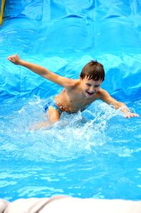 Cheerful boy running in swimming pool