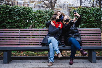 Woman sitting on bench in park