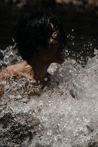 Close-up of woman splashing water