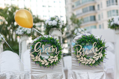 Groom and bride text on chairs during wedding ceremony