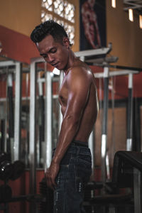 Shirtless man exercising in gym