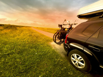 Transport e bikes by car. a roof rack stores luggage on the journey. sunset. suv with gas tank.