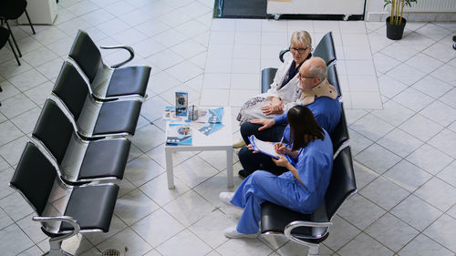 Side view of woman using mobile phone while sitting on chair