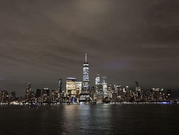 Illuminated buildings in city against sky at night