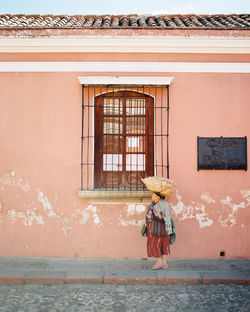 Full length of woman standing against building