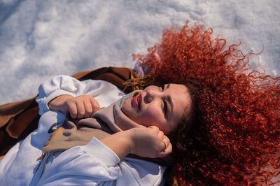 Portrait of young woman lying on bed