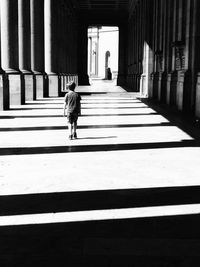 Rear view of boy walking in historic building