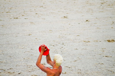 Woman with red umbrella on sand at beach