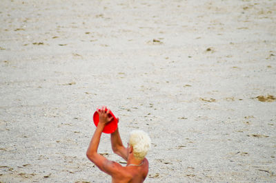 High angle view of man playing with plastic disc at beach