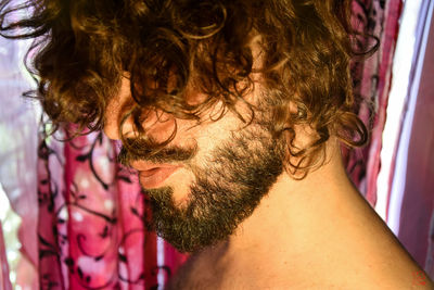 Close-up of man with beard and curly hair at home