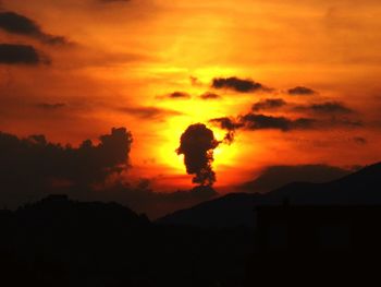 Silhouette mountain against orange sky