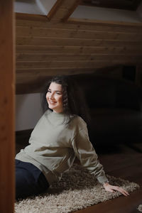 Beautiful young woman sitting on floor