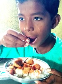 Close-up portrait of boy eating food
