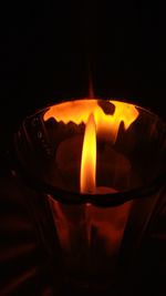 Close-up of lit candle against black background