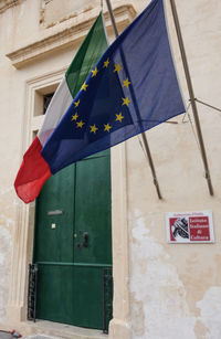 Low angle view of flags hanging on building