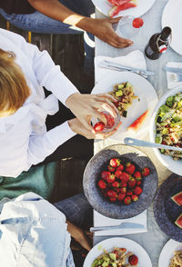 High angle view of multi-ethnic friends having lunch at table on sunny day