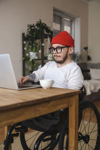 Man with disability using laptop at home