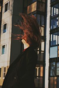 Portrait of woman standing against building