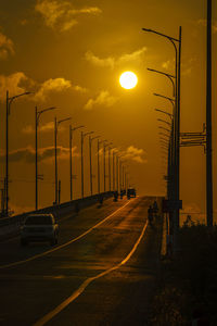 Empty road against sky during sunset