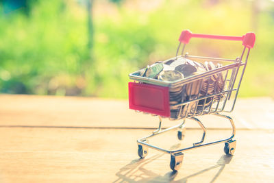 Close-up of toy shopping cart with coins 