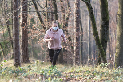 Full length of man standing on field in forest