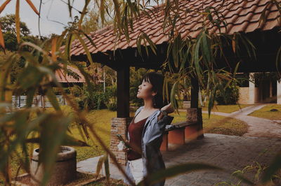 Young woman standing by gazebo at park