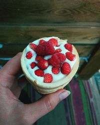 Close-up of hand holding strawberry