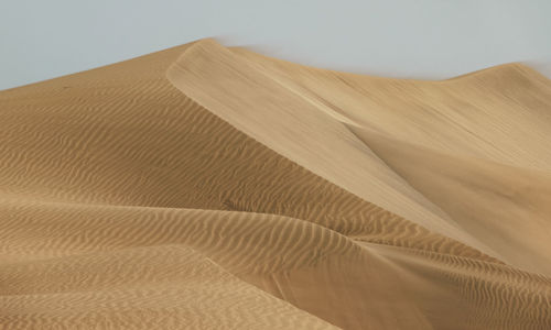 Close-up of sand dune in desert against sky